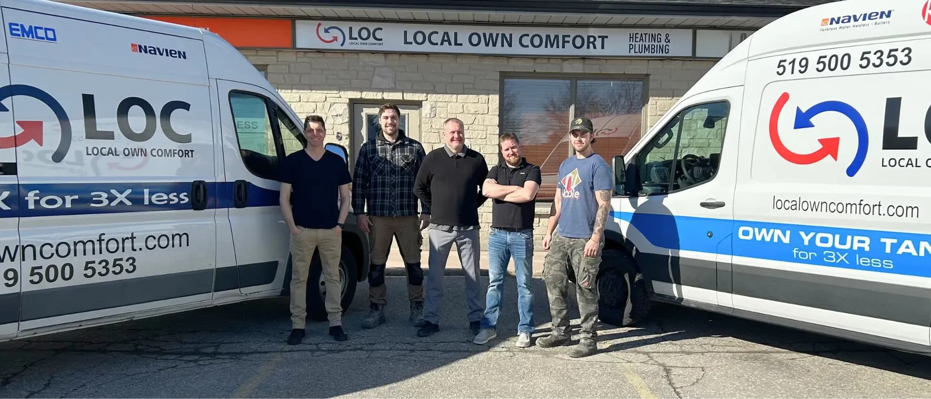 The Local Own Comfort team standing between two LOC service vans outside the shop